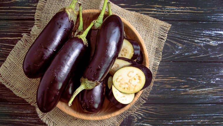 Whole eggplant on wooden background